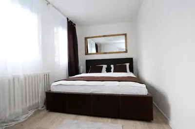 a bedroom with a bed with a mirror on the wall at Apartman City Lux in Banja Luka