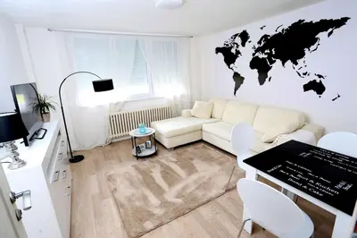a living room with a white couch and a world map on the wall at Apartman City Lux in Banja Luka
