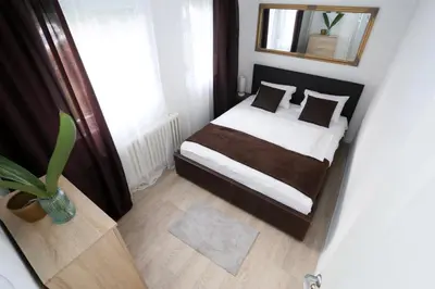 a small bedroom with a bed and a mirror at Apartman City Lux in Banja Luka