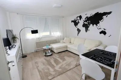 a living room with a white couch and a world map on the wall at Apartman City Lux in Banja Luka