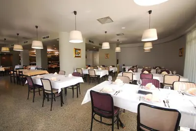 a dining room with white tables and chairs at Banja Kulaši in Kulaši
