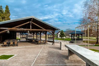 a pavilion with tables and benches in a park at Banja Kulaši in Kulaši