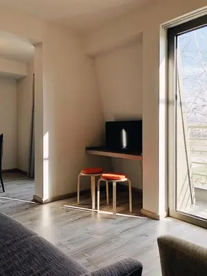 a living room with two stools in front of a window at Banja Kulaši in Kulaši