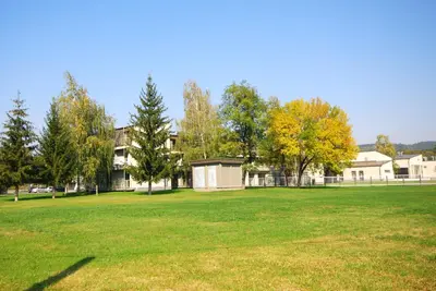 a large grassy field in front of a building at Banja Kulaši in Kulaši
