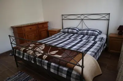 a bedroom with a bed with a black frame and pillows at Sobe-Apartmani Modriča in Modriča