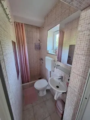a bathroom with a white toilet and a sink at Sobe-Apartmani Modriča in Modriča