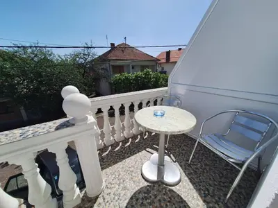 a small table and a chair on a balcony at Sobe-Apartmani Modriča in Modriča