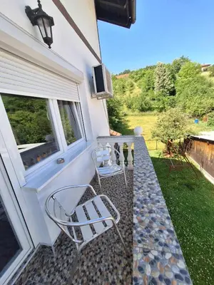 a patio with two chairs and a window at Sobe-Apartmani Modriča in Modriča