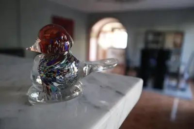 a glass figurine of a bird sitting on a table at Sobe-Apartmani Modriča in Modriča