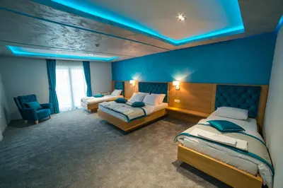 a bedroom with two beds and a blue ceiling at Motel Felikitas in Laktaši
