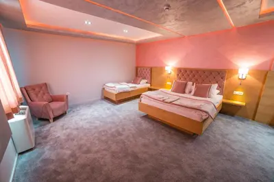 a hotel room with two beds and a chair at Motel Felikitas in Laktaši