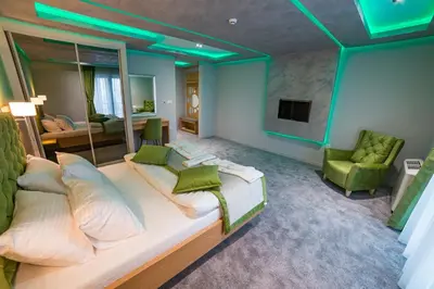 a bedroom with a large bed and a living room at Motel Felikitas in Laktaši