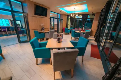 a restaurant with blue chairs and tables and windows at Motel Felikitas in Laktaši