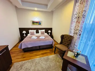 a hotel room with a bed and a chair at HOTEL MINERO in Tuzla