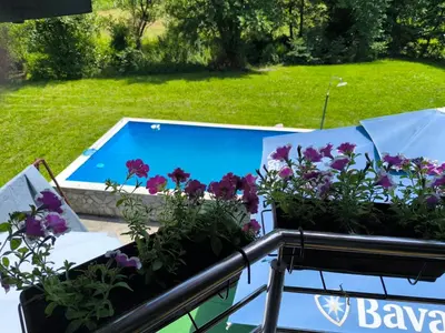 a swimming pool with flowers in a garden at Softa in Travnik