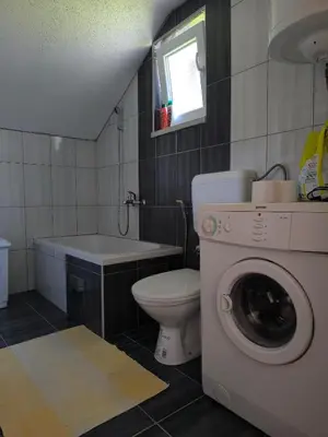 a bathroom with a toilet and a washing machine at Softa in Travnik