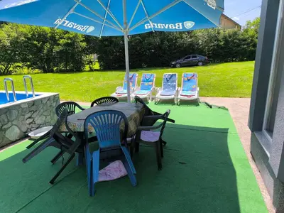 a table with chairs and an umbrella on a patio at Softa in Travnik