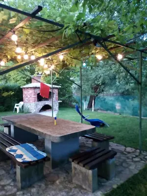 a picnic table with a blue bird under a pergola at ENNI in Bihać
