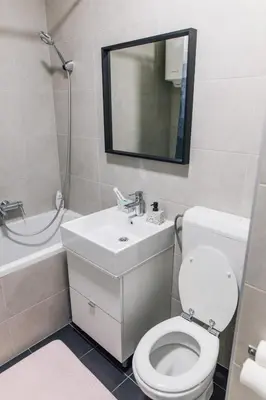 a bathroom with a toilet and a sink and a mirror at Apartment Jupiter in Tuzla
