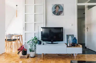 a living room with a flat screen tv on a white cabinet at Apartment Jupiter in Tuzla