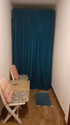 a room with a table and chairs and a blue curtain at Apartman Nena in Banja Luka