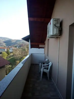 a balcony with a table and a tv on the wall at Apartmani 