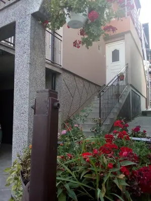 a building with a bunch of flowers in a garden at Apartmani 