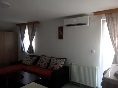 a living room with a red couch and windows at Apartmani 