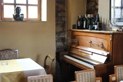 a piano in a room with a table and a window at Motel Alas in Banja Luka