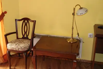 a table and a chair and a lamp in a room at Motel Alas in Banja Luka