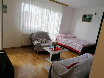 a living room with a bed and a chair at Good Host in Banja Luka