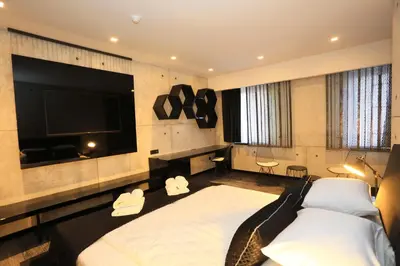 a bedroom with a large bed and a flat screen tv at Carpe Diem Boutique Hotel in Zenica