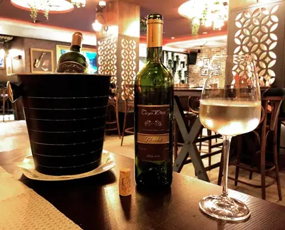 two bottles of wine sitting on a table with a glass at Carpe Diem Boutique Hotel in Zenica