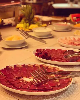 a table with plates of food and utensils on it at Carpe Diem Boutique Hotel in Zenica
