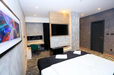 a hotel room with a bed and a tv at Carpe Diem Boutique Hotel in Zenica