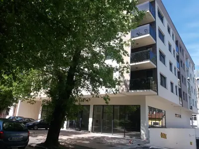 a building with a tree in front of it at NM Apartman in Banja Luka