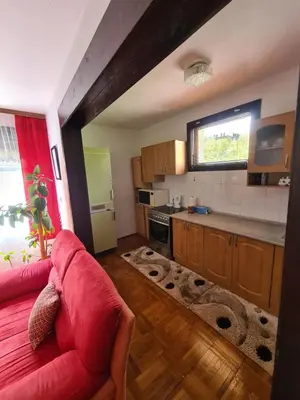 a living room with a red couch and a kitchen at Horizont apartmans in Jajce