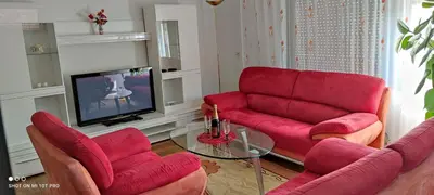 a living room with red couches and a tv at Horizont apartmans in Jajce