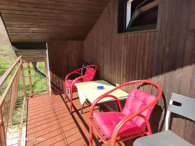 two red chairs and a table on a porch at Horizont apartmans in Jajce