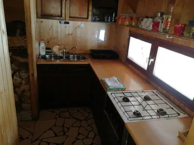 a small kitchen with a stove and a sink at Koliba - Prokoško jezero in Fojnica