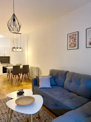 a living room with a blue couch and a table at City Break Apartment in Visoko