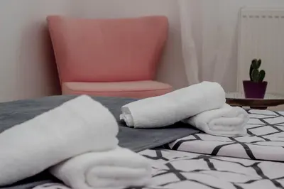 a room with two rolled towels and a chair at City Break Apartment in Visoko