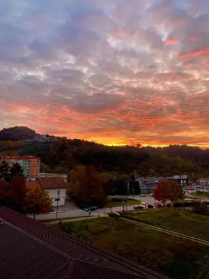 a sunset over a city with a street and trees at City Break Apartment in Visoko