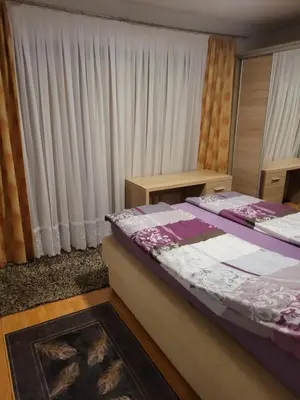 a bedroom with two beds and a window with curtains at Apartman View Una in Bihać