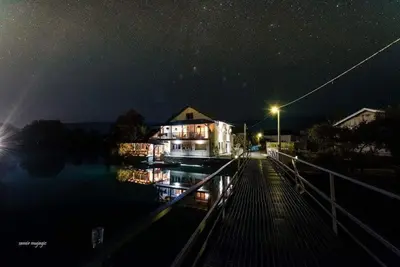 a house on a dock in the water at night at Apartman View Una in Bihać