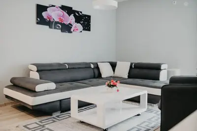 a living room with a black couch and a white coffee table at Prenoćište Park in Modriča