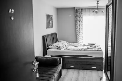 a bedroom with a bed and a couch next to a window at Prenoćište Park in Modriča
