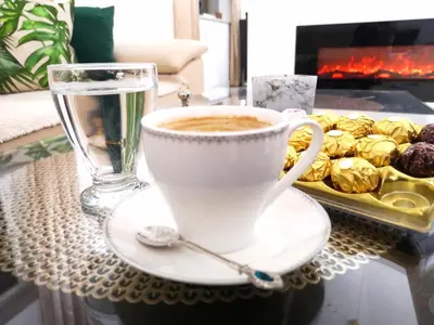 a cup of coffee and a glass of water on a table at Villa Diamond in Bihać