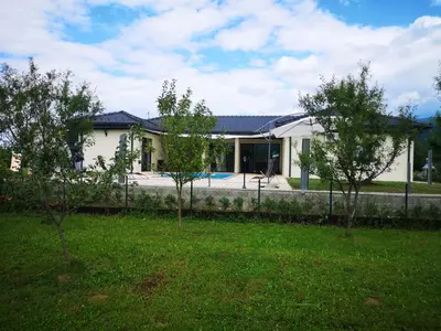 a white house with a fence in a yard at Villa Diamond in Bihać