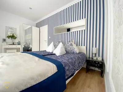 a bedroom with a bed with blue and white stripes at Villa Diamond in Bihać